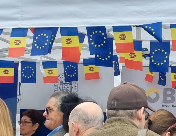 Aufnahme einer Menschenmenge; über den Köpfen hängen Girlanden mit moldauischen und EU-Flaggen.