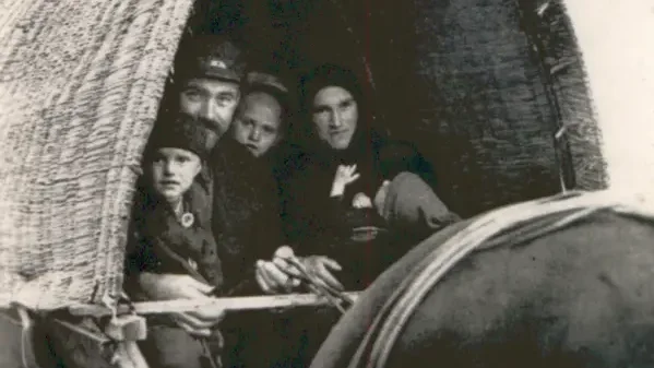 Ein Paar mit zwei Kindern in einem Planwagen.