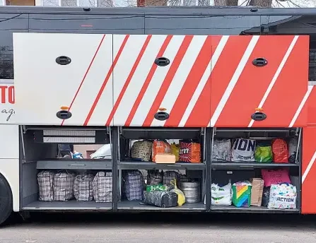 Ein Reisebus mit offenem Kofferraum in dem sich viele bunte Taschen befinden