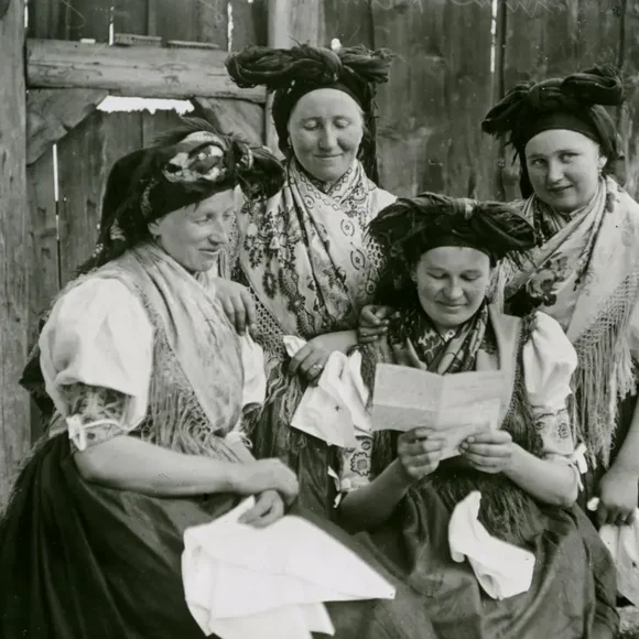 Vier Frauen in Tracht lesen einen Brief.