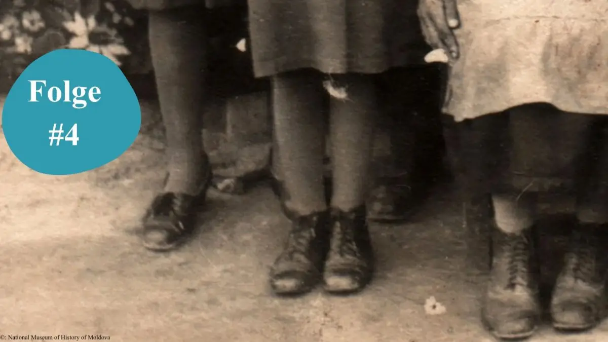 Ausschnitt aus einer historischen Fotografie mit einem Detail der Füße dreier Mädchen in dicken Strümpfen und schwarzen Schuhen.