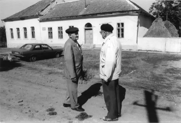 Zwei Männer begegnen sich auf einer Dorfstraße