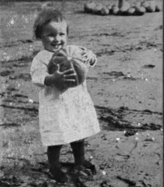 Ein kleines Mädchen mit einem Kürbis in den Händen