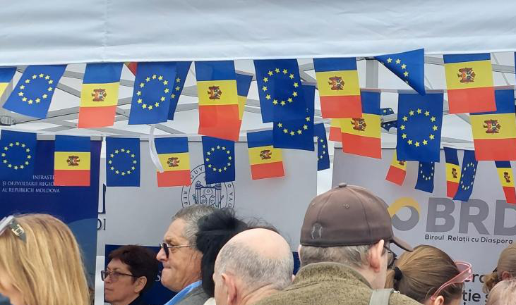 Aufnahme einer Menschenmenge; über den Köpfen hängen Girlanden mit moldauischen und EU-Flaggen.