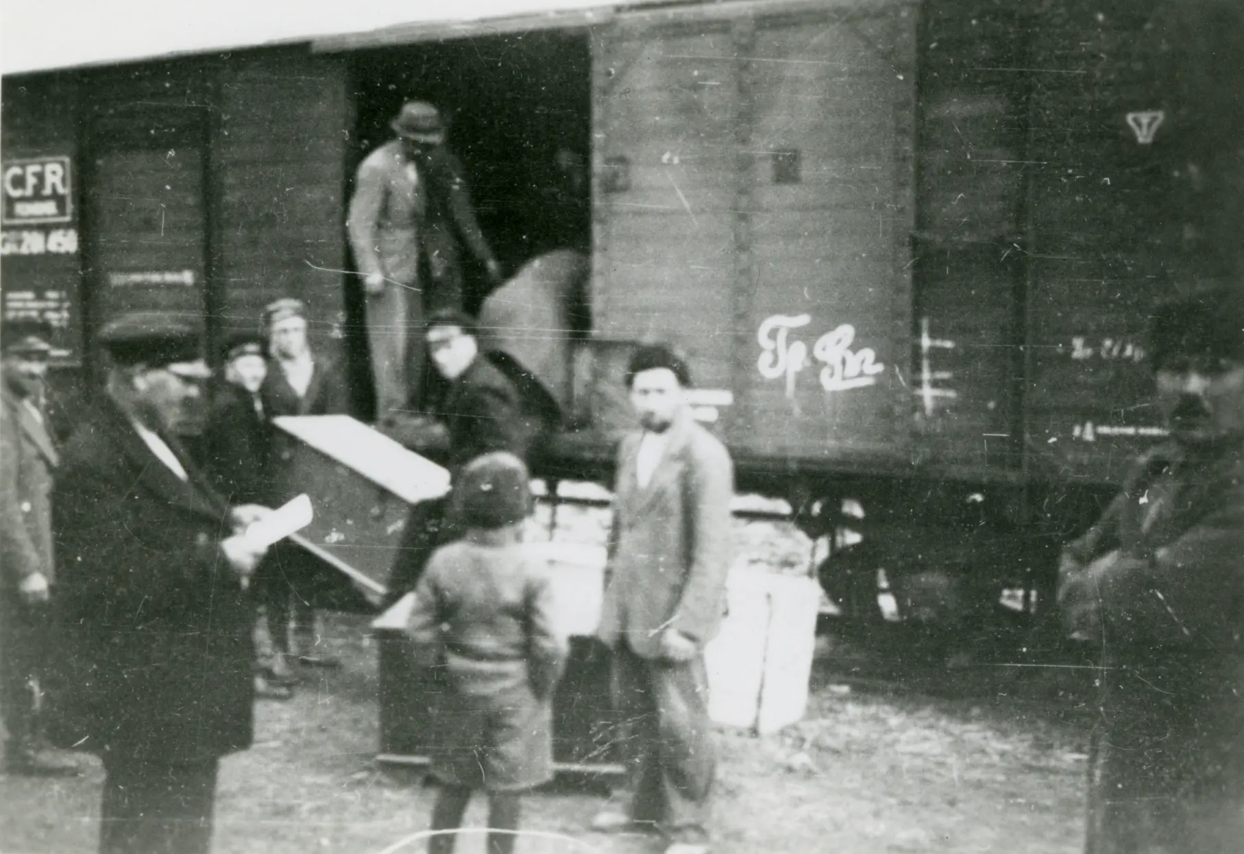 Personen laden Gepäck in einen Eisenbahnwagon. Die Szene steht in Zusammenhang mit der Umsiedlung der Dobrudschadeutschen, aufgenommen in Cobadin (1940). Foto aus einem Album im Nachlass Johannes Niermann/Otto Klett.