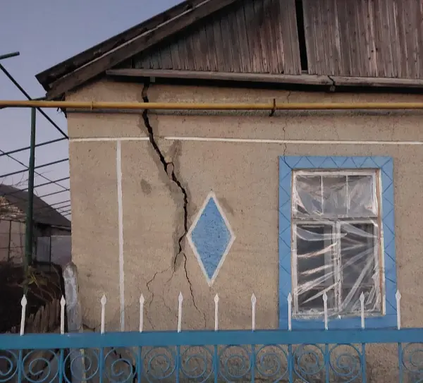 Giebelansicht eines Hauses mit einem tiefen Riss im Mauerwerk.